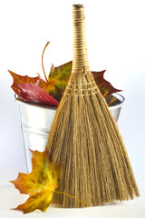 jesienne liście w wiadrze z miotłą