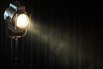 vintage theatre spot light on black curtain with smoke