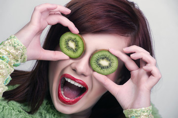 Kiwi. Healthy fruit funny woman holding kiwi fruit for her eyes.