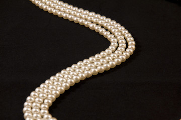 Necklace of pearls on black background
