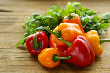 świeże kolorowe papryki na drewnianym tle