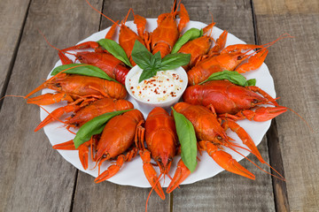 Talerz z czerwonymi gotowanymi rakami z białym sosem na boku