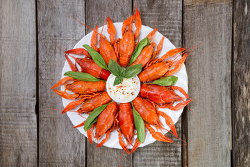 Talerz z czerwonymi gotowanymi rakami na drewnianym stole, widok z góry