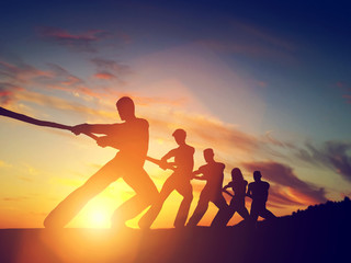 Grupa ludzi, zespół ciągnący linię, grający przeciąganie liny. Praca zespołowa