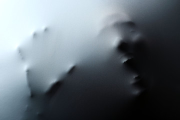 Krzycząca ludzka twarz ręką naciskająca przez materiał jako tło grozy