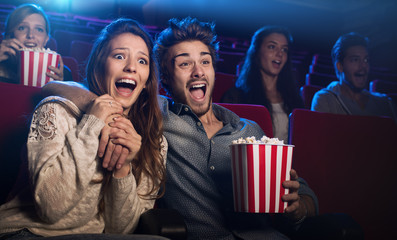 Young couple at the cinema watching an horror movie