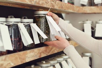 Biała herbata .Kobieta wybiera rodzaj herbaty podczas zakupów w sklepie herbacianym