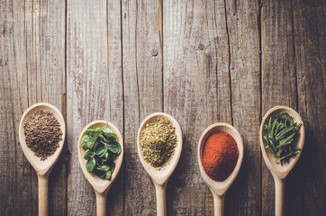 Aromatyczne zioła i przyprawy na drewnianych łyżkach