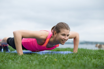 Young woman doing push up exercises outdoor