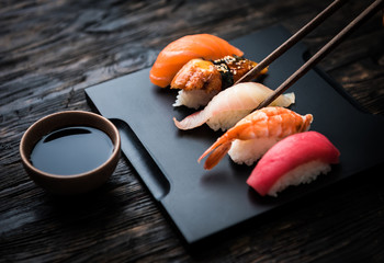 bliska sushi sashimi z pałeczkami i soi na czarnym tle