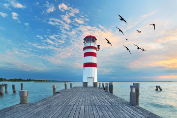 o zachodzie słońca przy latarni morskiej nad jeziorem