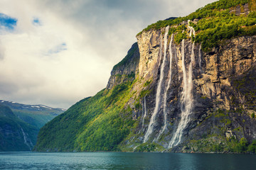 Fiord Geiranger. Wodospad Siedmiu Sióstr, Norwegia. Krajobraz górski z chmurnym niebem. Piękna natura.