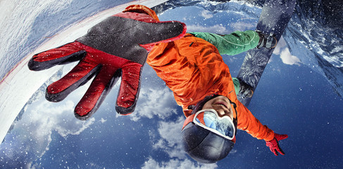 Tło sportowe. Sporty zimowe. Snowboarder skoki przez powietrze z głębokim błękitnym niebem w tle.