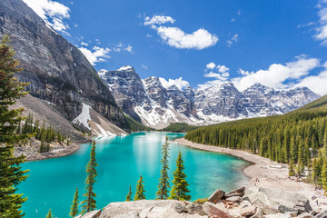 Moraine lake in Banff National Park, Canadian Rockies, Canada. Sunny summer day with amazing blue sky. Majestic mountains in the background. Clear turquoise blue water.