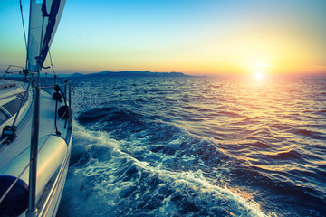 Łódź w regatach żeglarskich podczas zachodu słońca.