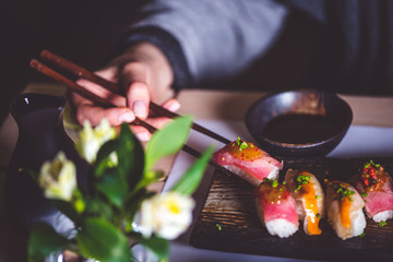 Mężczyzna jedzenie sushi zestaw pałeczkami w restauracji