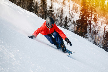 sportowiec z twardym snowboardem na slalom w ośrodku narciarskim wchodzi na zakręt, region Murmańsk, Rosja. Połysk słońca. Tonowanie.