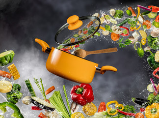 Świeże warzywa latające do garnka na ciemnym tle