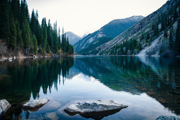 Majestic blue mountain lake with green trees