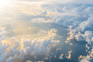 White clouds and blue sky at sunrise, view from above air plane window.