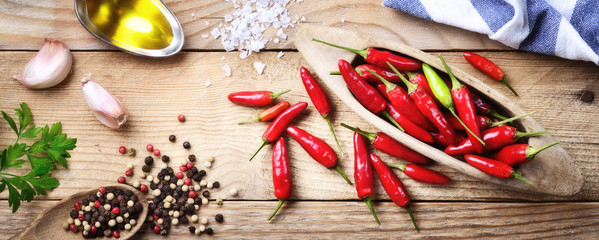 Czerwonego pieprzu chili, pieprzu, pietruszki, czosnku i ekstra dziewiczy oliwa z oliwek na drewnianym tle
