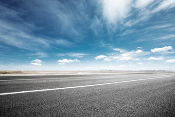 empty asphalt road with snow mountains in blue cloud sky