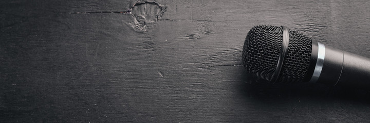 Mikrofon na drewnianym czarnym stole. Studio. Widok z góry. Wolne miejsce na tekst. Skopiuj miejsce