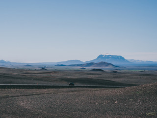 one car on road with black sand and mountains around, Iceland