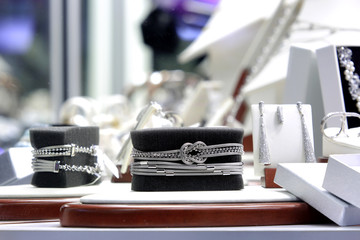 Srebrny naszyjnik, branzoletka na czarnym tle w sklepie jubilerskim.