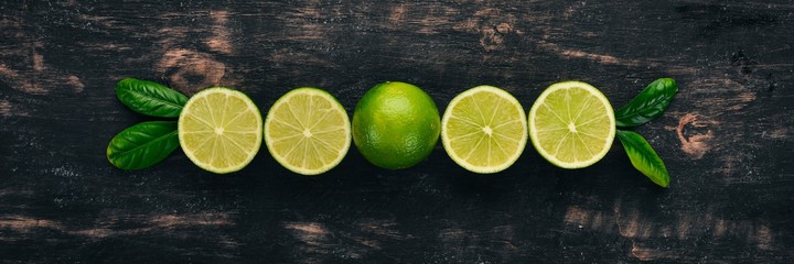 Świeże zielone limonki. Owoce. Na drewnianym tle. Widok z góry.