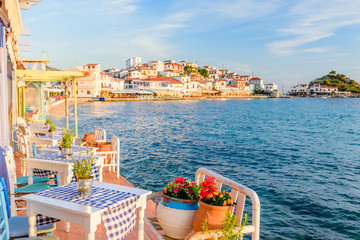 wnętrze greckiej tradycyjnej tawerny nad morzem, ozdobionej kwiatami, w popularnej wiosce turystycznej Kokkari, wyspa Samos, Grecja