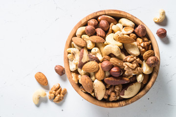 Nuts assortment in a bowl on white top view.