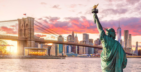 Statue Liberty and New York city skyline at sunset