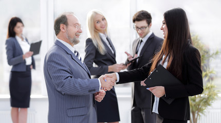 assistant meets a businessman with a handshake. meetings and partnership