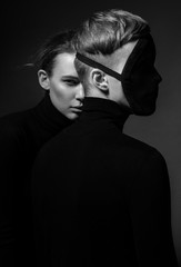 Portret kobieta z mężczyzna w twarzy masce pozuje na ciemnym tle