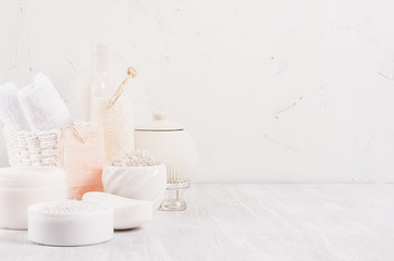 Białe delikatne kosmetyki do pielęgnacji ciała i skóry w białej nowoczesnej łazience na półce, miejsce na kopię.