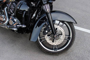 Siekacz stojący na drodze. Koło motocykla.