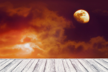 Tło ciemnego nocnego nieba z tajemniczymi chmurami, zaćmieniem czerwonego księżyca i stołem w stylu shabby chic. Księżyc jest zabrany przeze mnie aparatem.