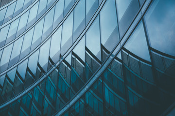 Abstract business modern city urban futuristic architecture background. Real estate concept, motion blur, reflection in glass of high rise skyscraper facade, toned blue picture with bokeh