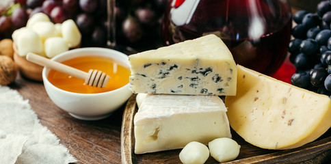 Ser i wino, karafki i okulary, drewniane tło, przekąska, winogrona, długi baner