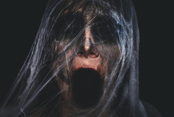 Krzyczący przerażający charakter zakrywający z spiderweb na czarnym tle