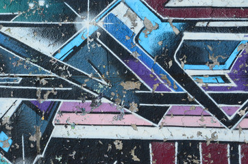 Fragment rysunków graffiti. Stara ściana ozdobiona plamami farby w stylu kultury ulicznej. Tekstura tło wielobarwny