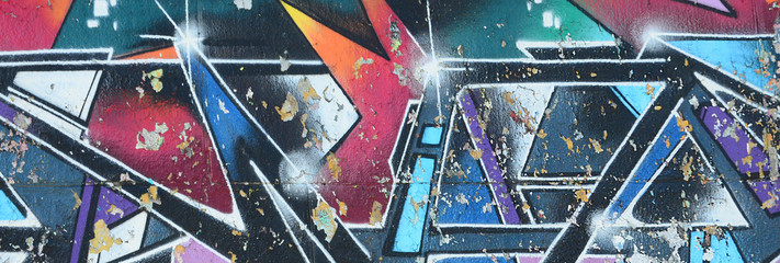 Fragment rysunków graffiti. Stara ściana ozdobiona plamami farby w stylu kultury ulicznej. Tekstura tło wielobarwny