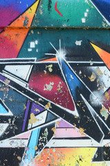 Fragment rysunków graffiti. Stara ściana ozdobiona plamami farby w stylu kultury ulicznej. Tekstura tło wielobarwny