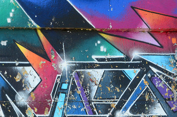 Fragment rysunków graffiti. Stara ściana ozdobiona plamami farby w stylu kultury ulicznej. Tekstura tło wielobarwny