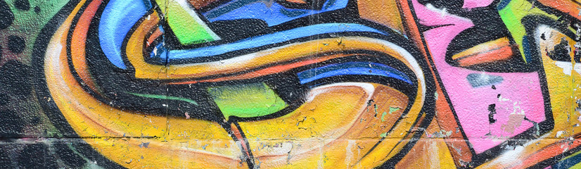 Fragment rysunków graffiti. Stara ściana ozdobiona plamami farby w stylu kultury ulicznej. Tekstura tło wielobarwny