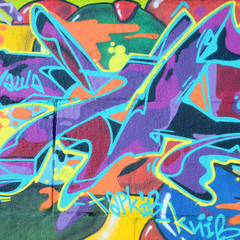 Fragment rysunków graffiti. Stara ściana ozdobiona plamami farby w stylu kultury ulicznej. Tekstura tło wielobarwny