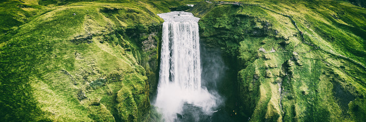 Islandia wodospad Skogafoss banner nature landscape. Panoramiczny miejsce przeznaczenia w Islandzkiej sławnej światowej punkt zwrotny atrakci turystycznej na Południowym Iceland. Widok z lotu ptaka drone góry wodospad.