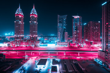 Piękny widok na Dubaj i Sheikh Zayed Rd, Zjednoczone Emiraty Arabskie. Panorama miasta. Efekt długiej ekspozycji w nocy. Duotone retro wave neon noir świeci kolorami