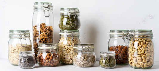Glass jars with Superfoods nuts and cereals stacked on top of each other